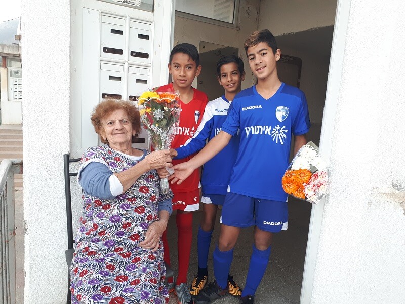 ילדי קבוצת הכדורגל איתוראן של קרית שמונה מבקרים קשישים. צילום: צוות מטב.
