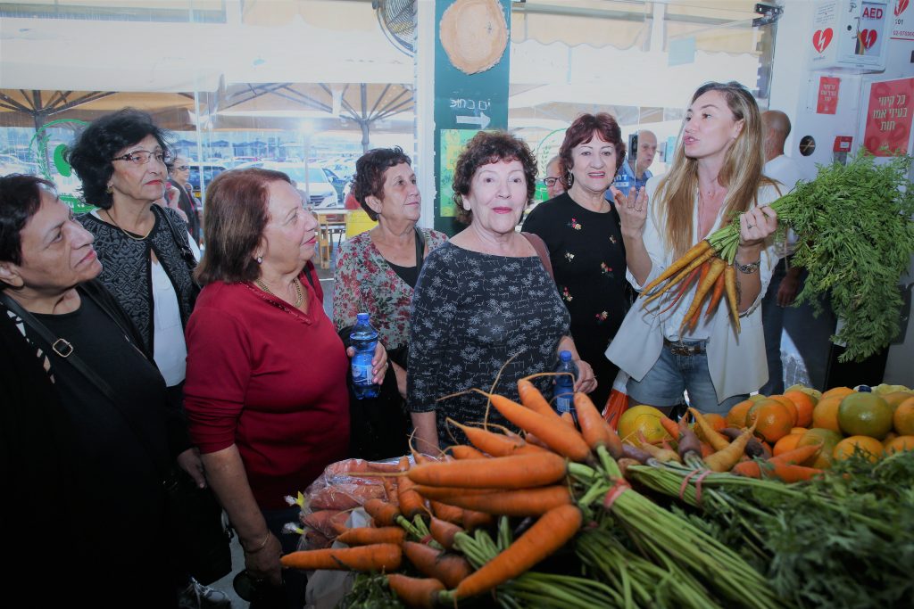 מחזירים אהבה 2018- מיכל אנסקי מארחת קשישות בשוק האוכל בנמל תל אביב. צילום: אלוני מור.